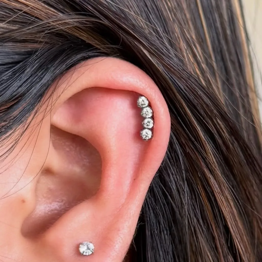 Row of four prong-set crystal studs along the upper helix with a small crystal stud on the lobe