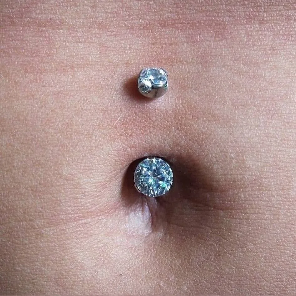 Navel piercing with a silver double crystal curved barbell