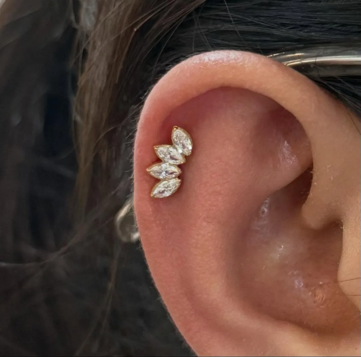 Upper cartilage piercing with a gold marquise crystal crown stud